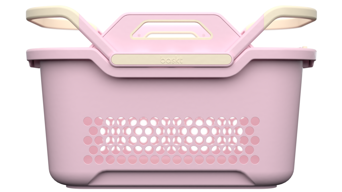 A plastic storage basket with a pink-colored body and cream handles, shown from a front-facing perspective on a solid white background.